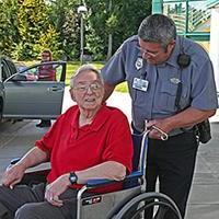 Security employee with patient in wheelchair at Main Entrance